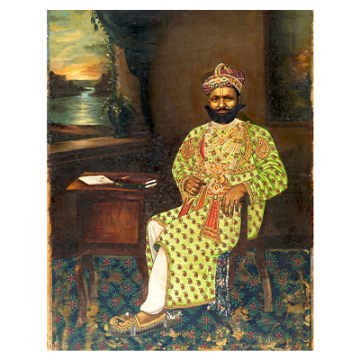 Portrait of a Indian Nobleman in traditional Jewellery and green attire sitting on a chair