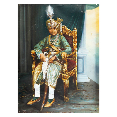 Portrait of a Young Prince in traditional Jewellery and attire sitting on a silver chair